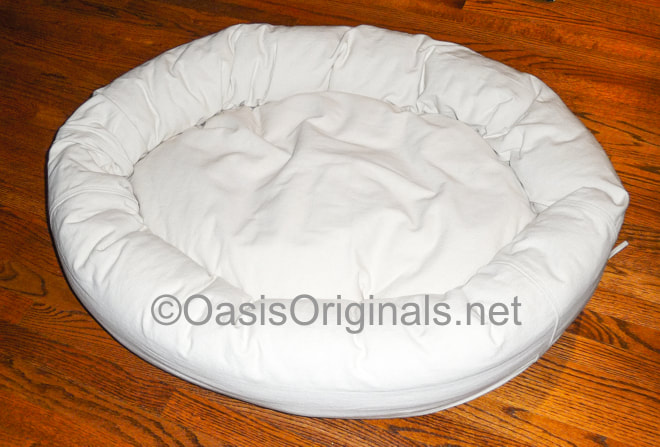 Round donut style dog bed with washable denim cover.